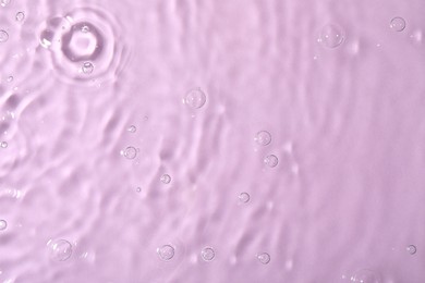 Closeup view of water with rippled surface on violet background