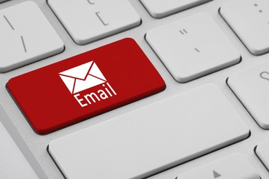 Image of Red button with word Email and illustration of envelope on keyboard, closeup