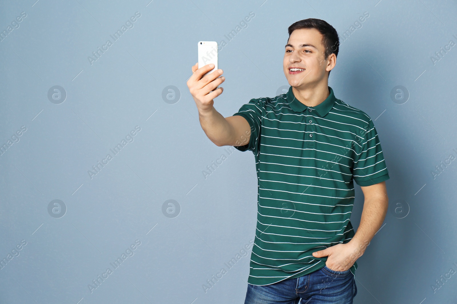 Photo of Young handsome man taking selfie against grey background