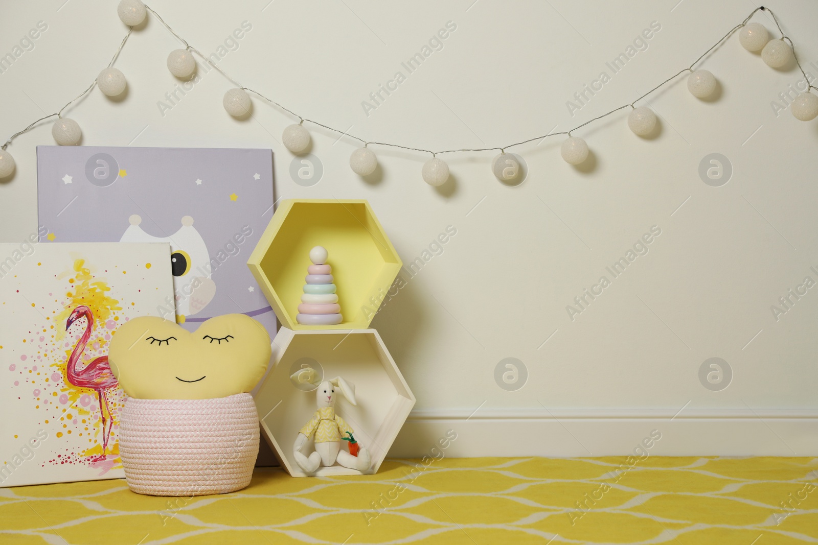 Photo of Posters and toys near light wall in baby room. Interior design