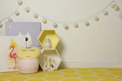 Posters and toys near light wall in baby room. Interior design