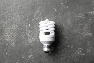 Photo of New fluorescent lamp bulb on grey stone surface, top view