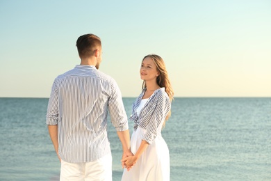 Photo of Happy young couple resting together on beach