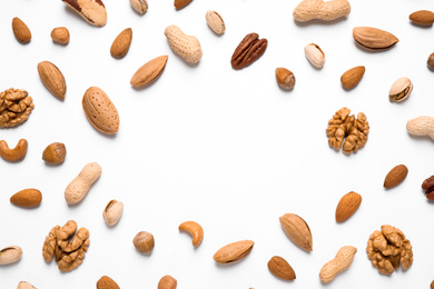 Different delicious nuts on white background, flat lay. Space for text