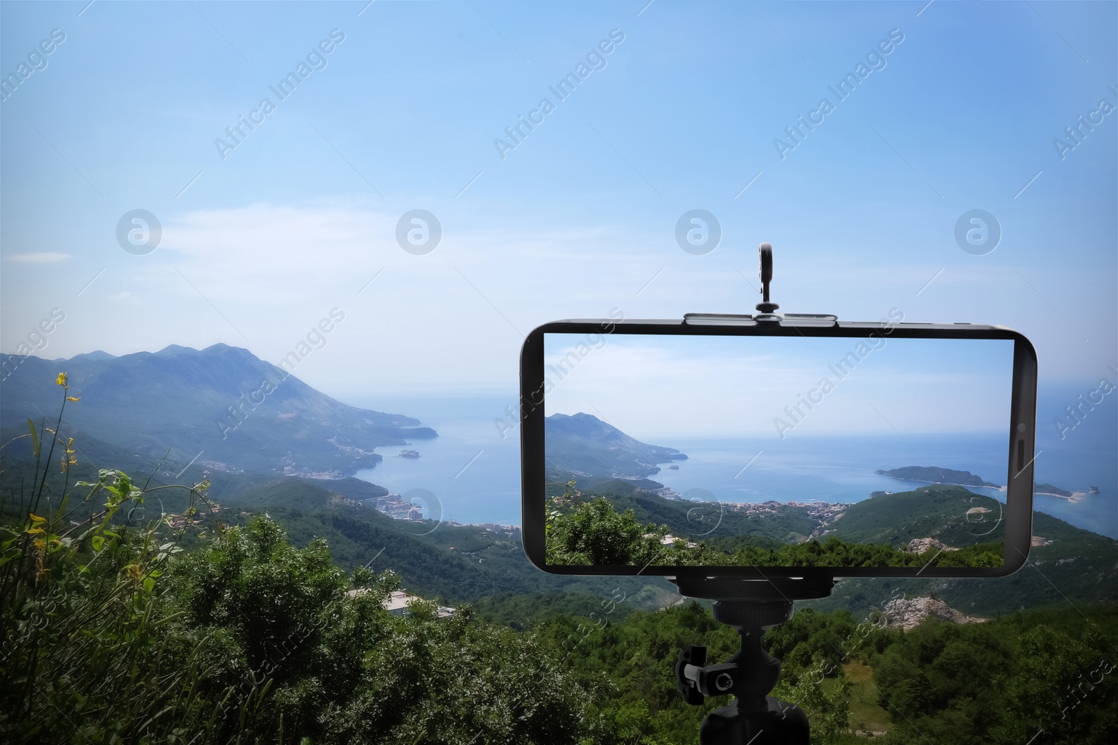 Image of Taking photo of beautiful mountain landscape with smartphone mounted on tripod