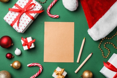 Flat lay composition with paper and Christmas decor on color background. Letter for Santa Claus