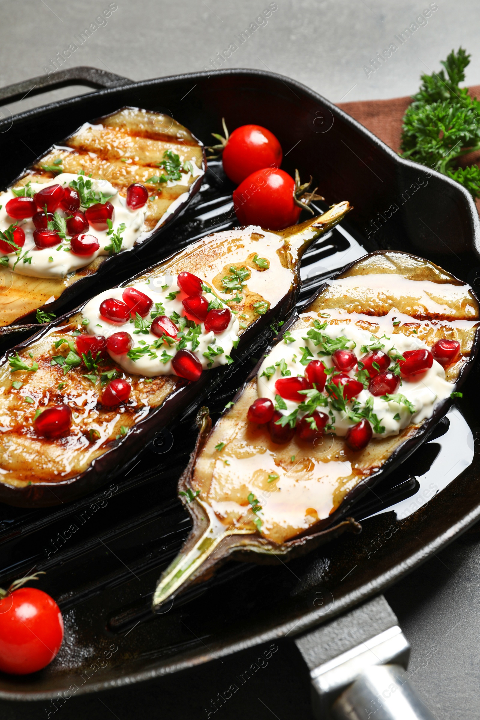 Photo of Grill pan with fried eggplants on table, closeup