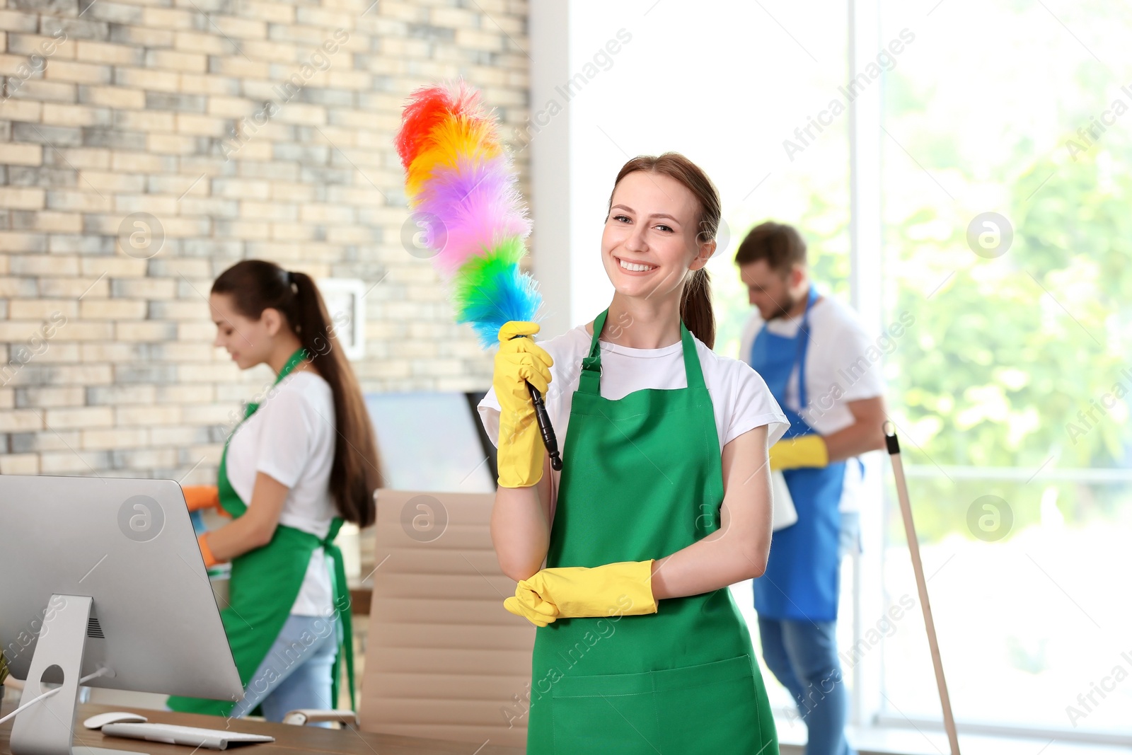 Photo of Team of professional janitors in uniform indoors