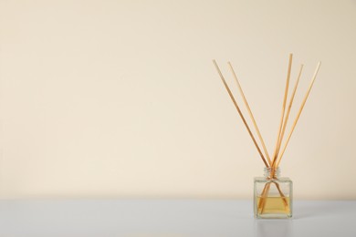 Aromatic reed air freshener on white table indoors. Space for text