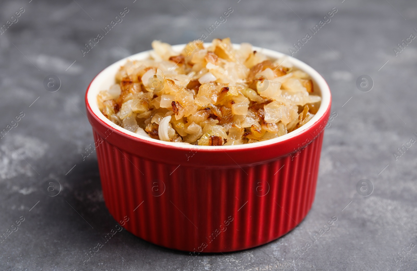 Photo of Tasty fried onion on grey table, closeup