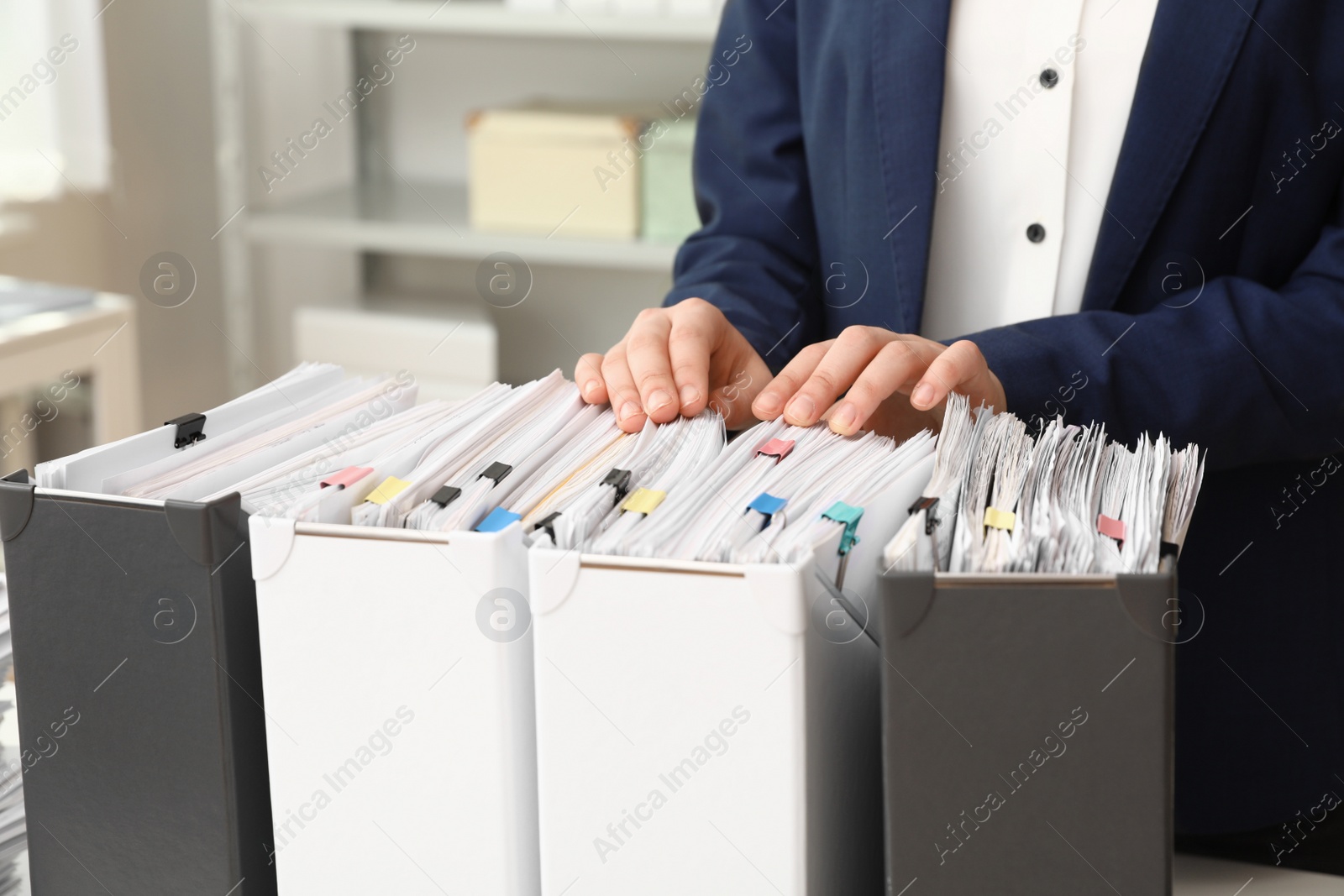 Photo of Woman taking documents from folder in archive, closeup