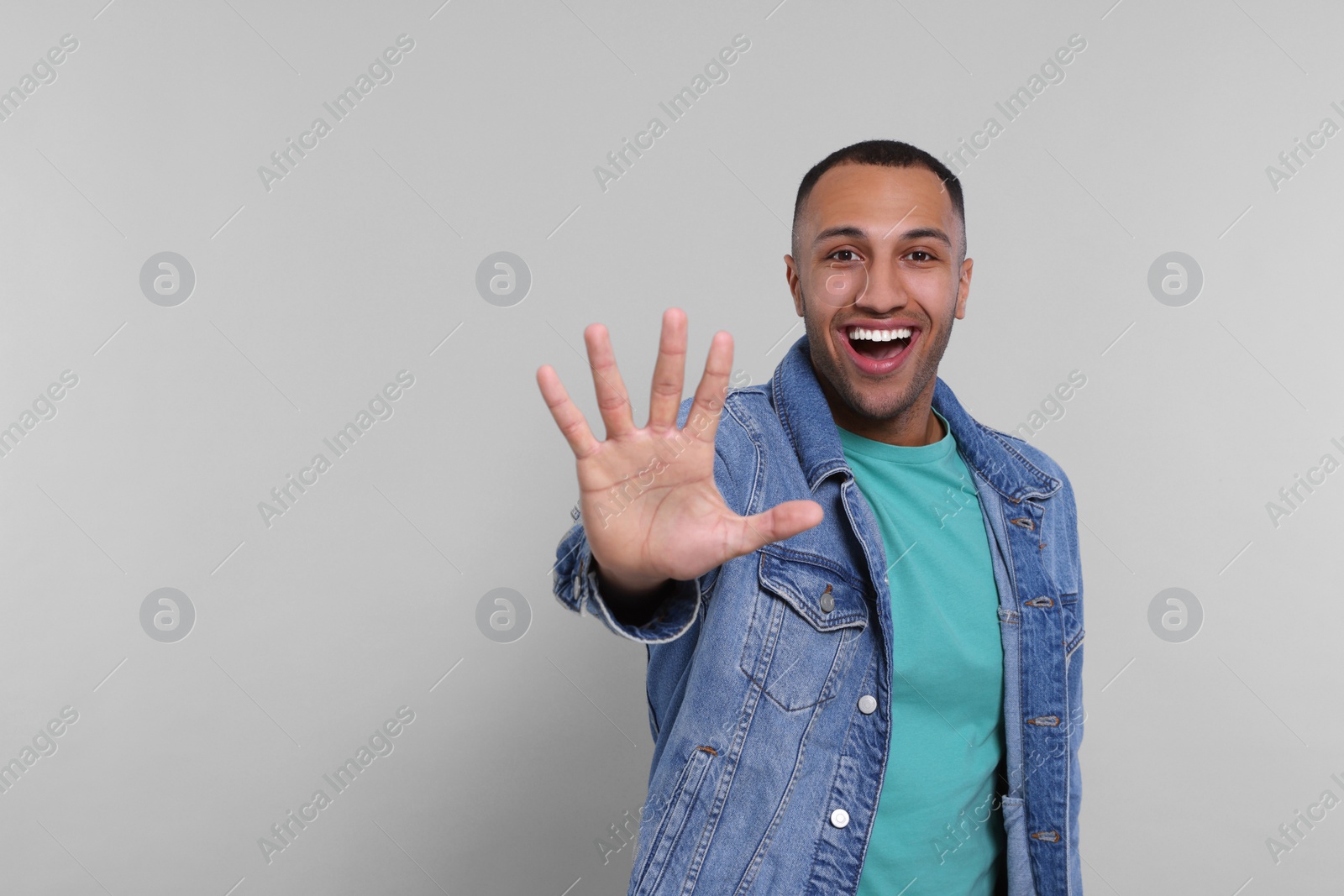 Photo of Man giving high five on grey background. Space for text