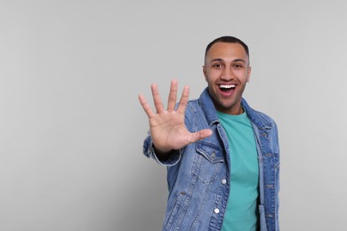 Man giving high five on grey background. Space for text