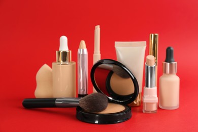 Photo of Foundation makeup products on red background. Decorative cosmetics