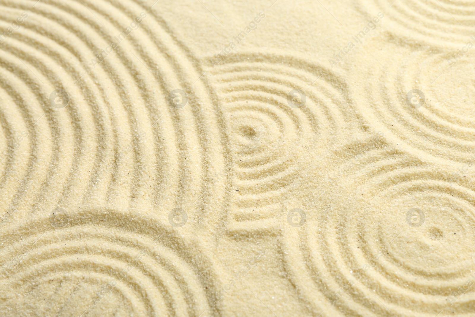 Photo of Zen rock garden. Circle patterns on beige sand, closeup