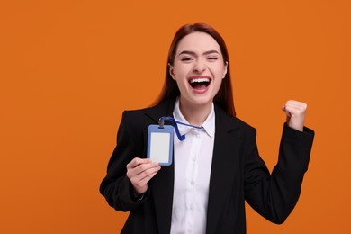 Happy woman with vip pass badge on orange background