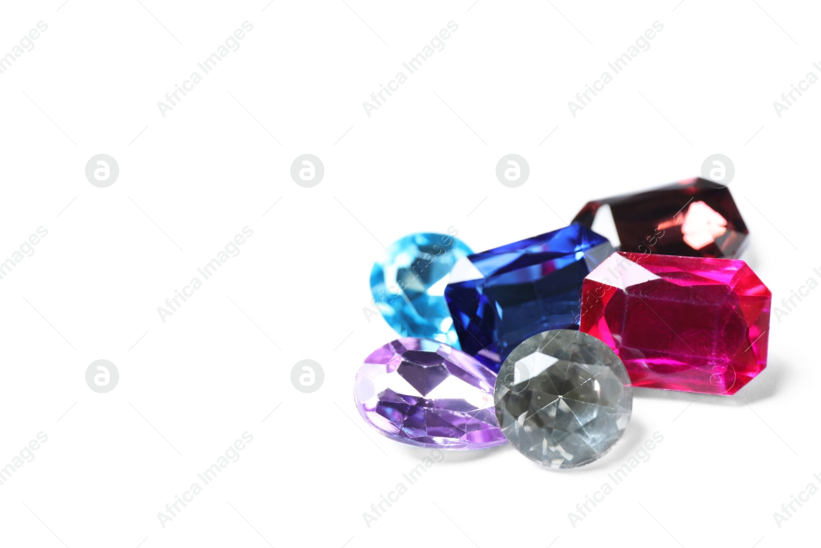 Photo of Different beautiful bright gemstones on white background