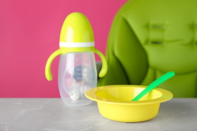 Photo of Set of plastic dishware on light table. Serving baby food