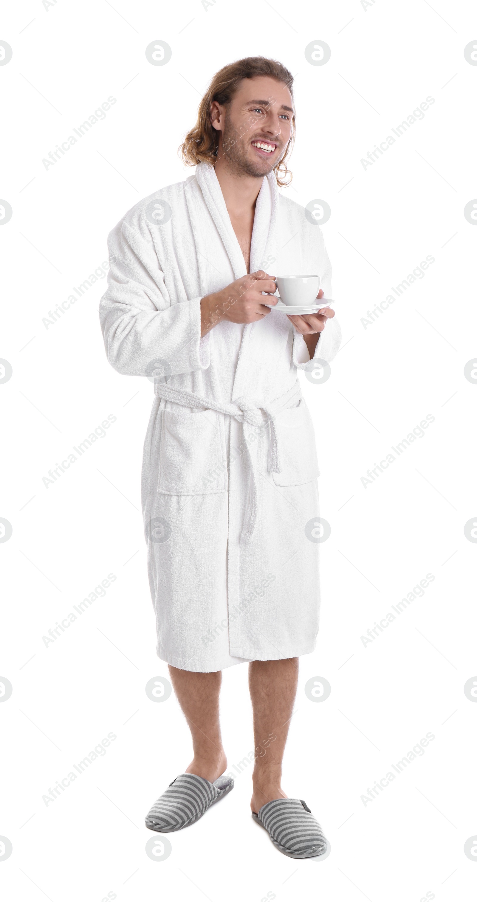 Photo of Young man in bathrobe with cup of drink on white background