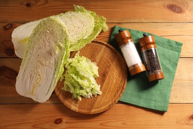 Photo of Fresh Chinese cabbage and spices on wooden table, flat lay