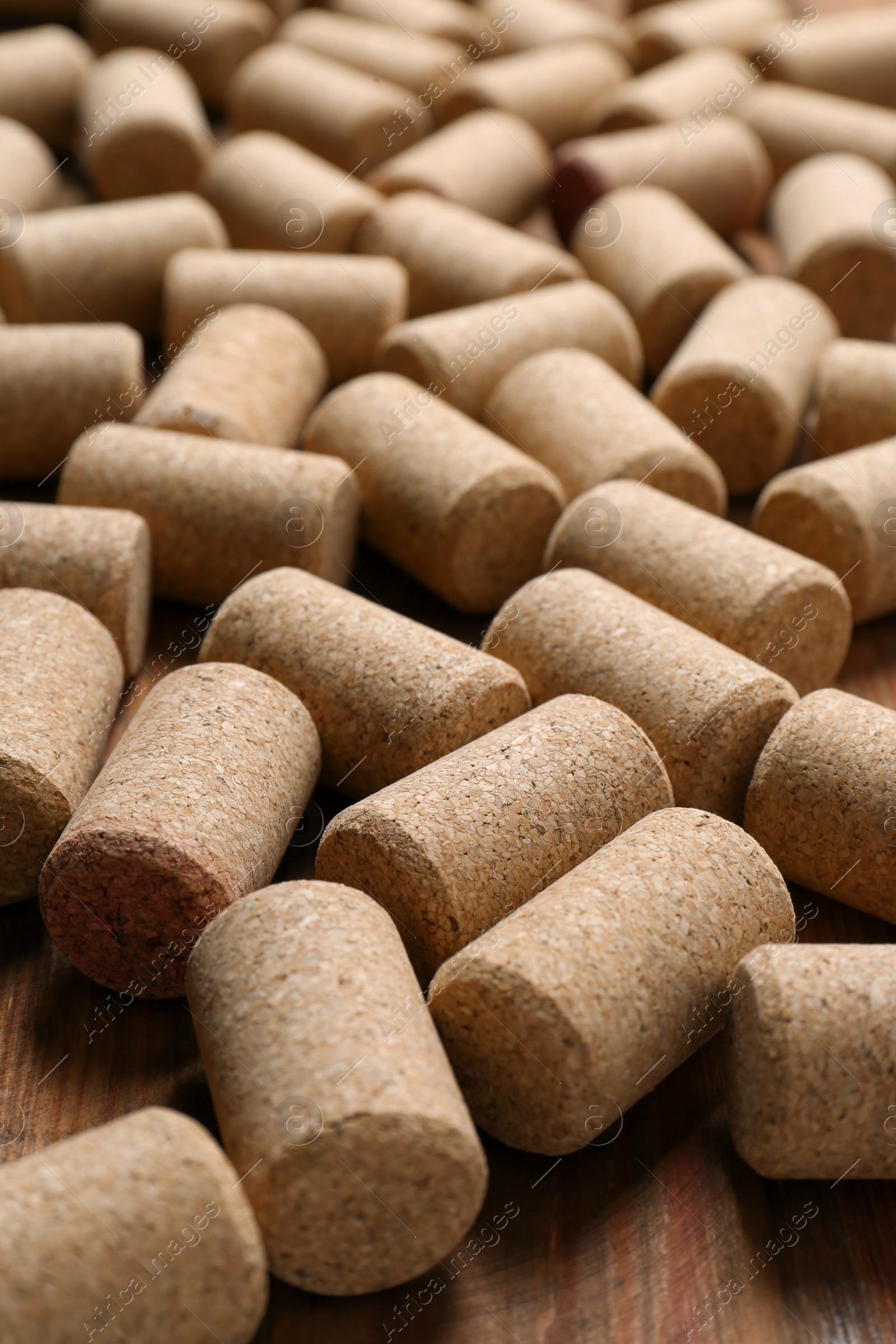 Photo of Many corks of wine bottles on wooden table, closeup