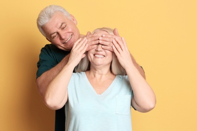 Adorable mature couple having fun against color background