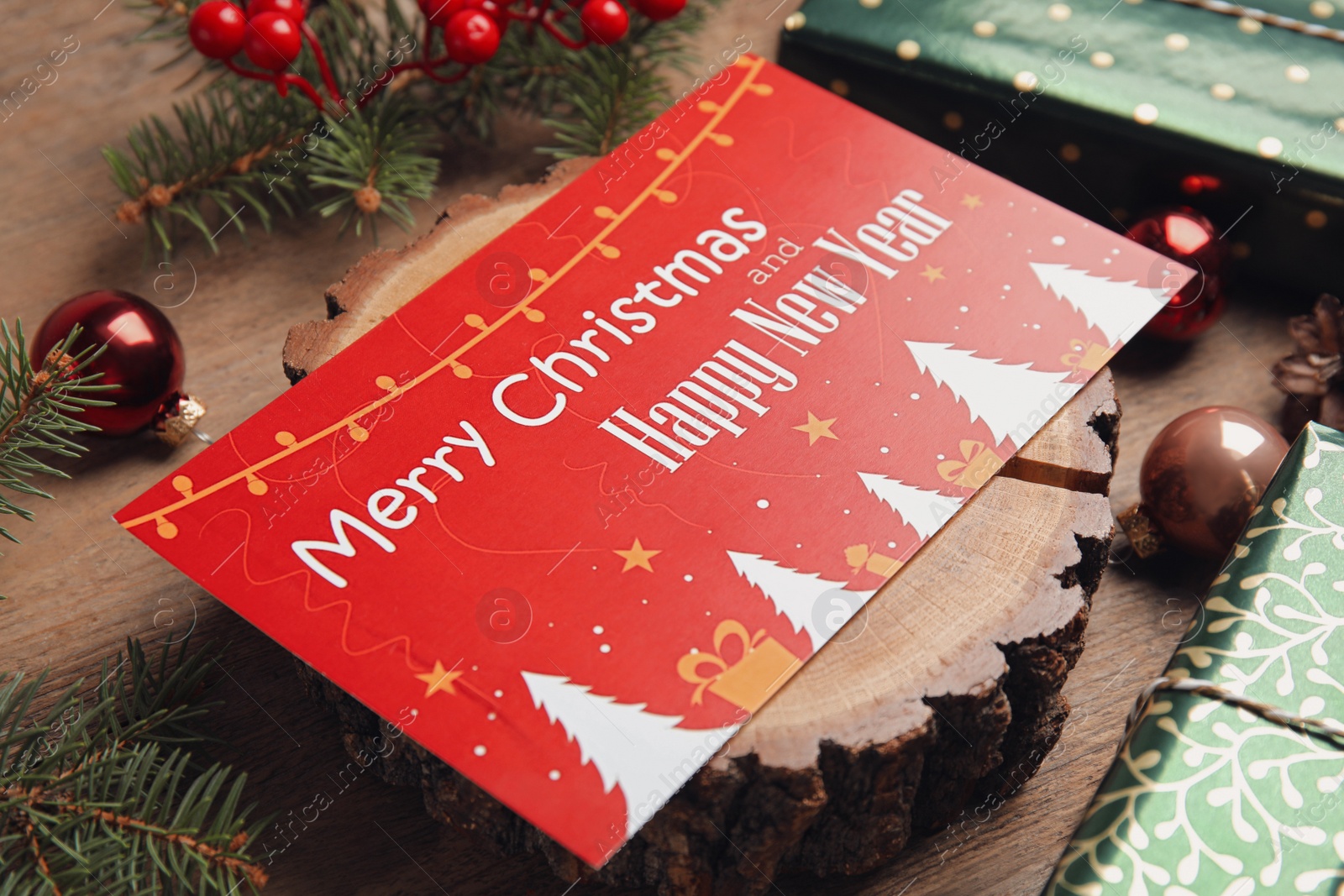 Photo of Greeting card and Christmas decor on wooden table, closeup