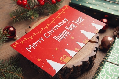 Photo of Greeting card and Christmas decor on wooden table, closeup