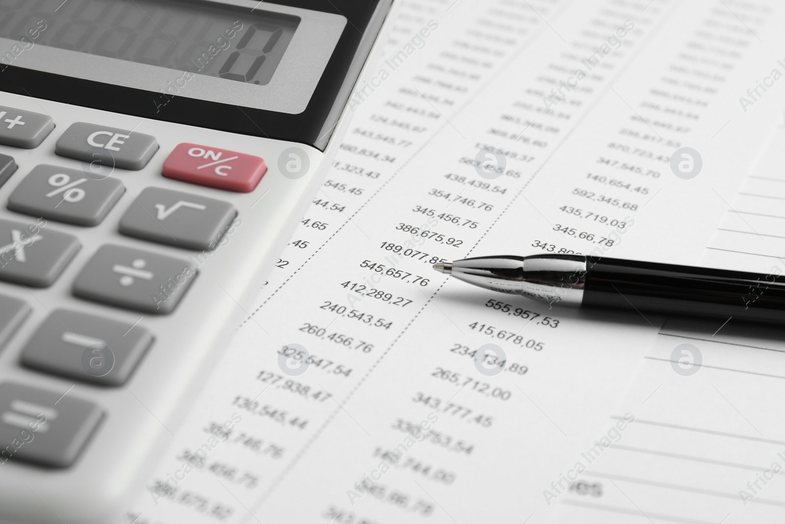 Photo of Calculator and pen on documents, closeup view