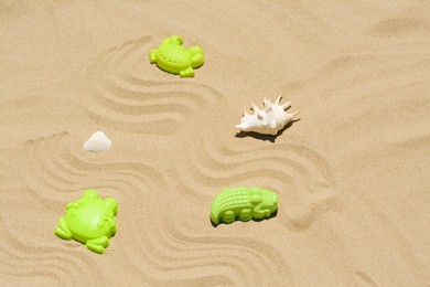 Photo of Plastic molds and shells on sand. Beach toy