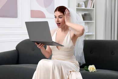 Photo of Surprised bride with laptop in living room