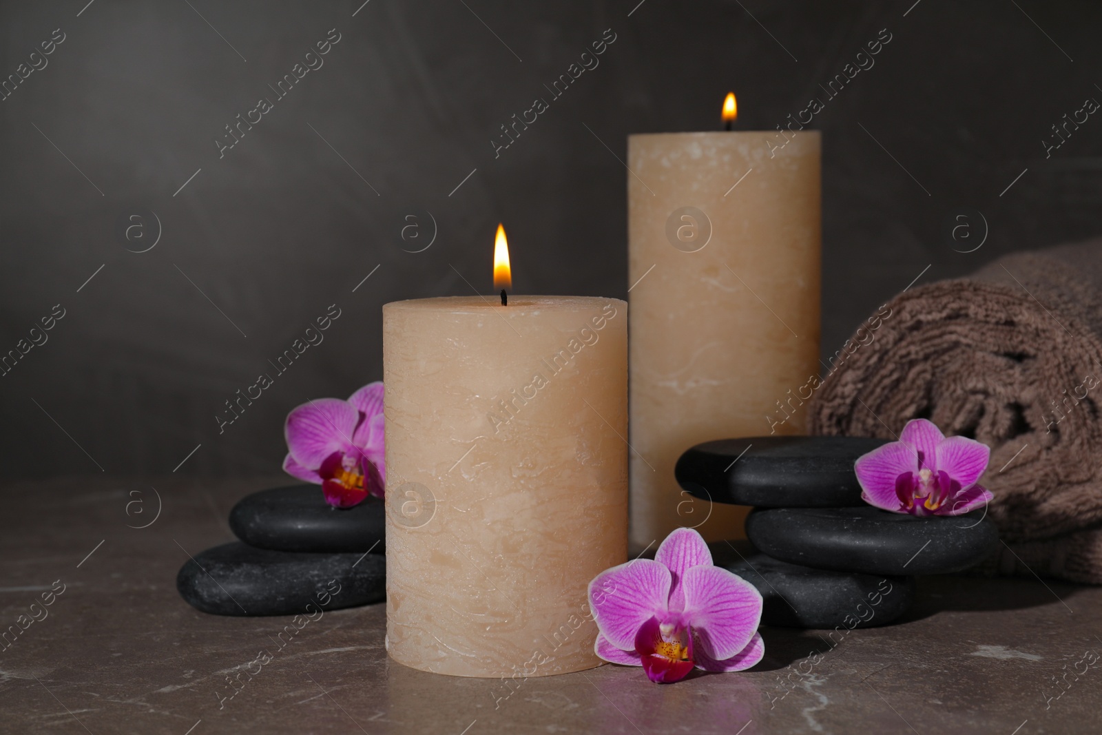 Photo of Composition with candles and spa stones on marble table