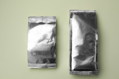 Photo of Blank foil packages on light background, flat lay