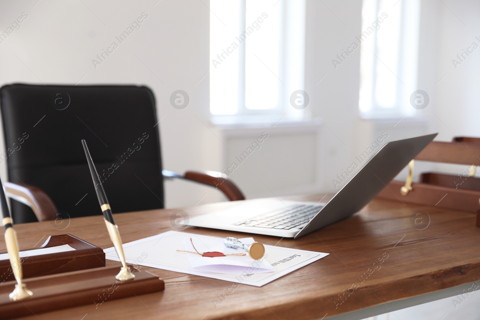 Photo of Vintage stamp, laptop and documents on desk in notary's office