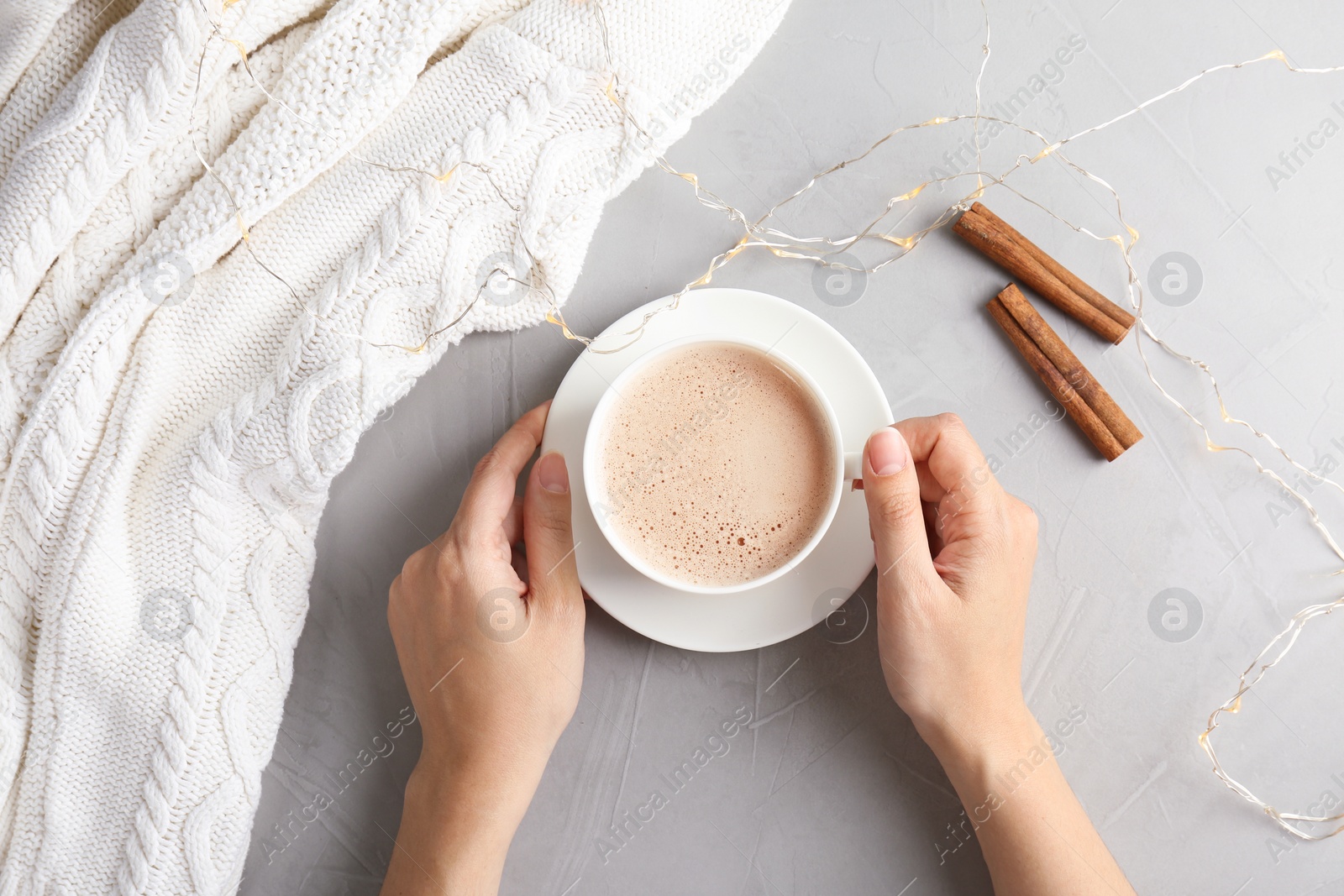 Photo of Woman with delicious hot cocoa drink at table, top view
