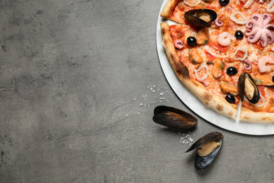 Photo of Delicious seafood pizza on grey table, flat lay. Space for text