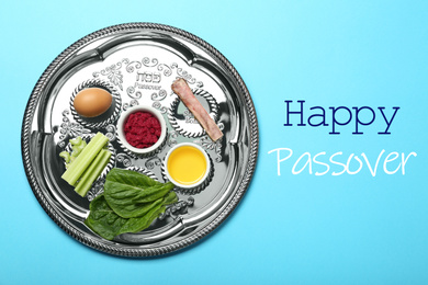 Image of Passover Seder plate (keara) with symbolic meal on light blue background, top view. Pesah celebration