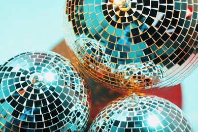 Photo of Bright shiny disco balls on color background, above view