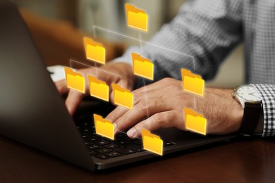 File system. Man using laptop at table, closeup. Scheme with folders over computer