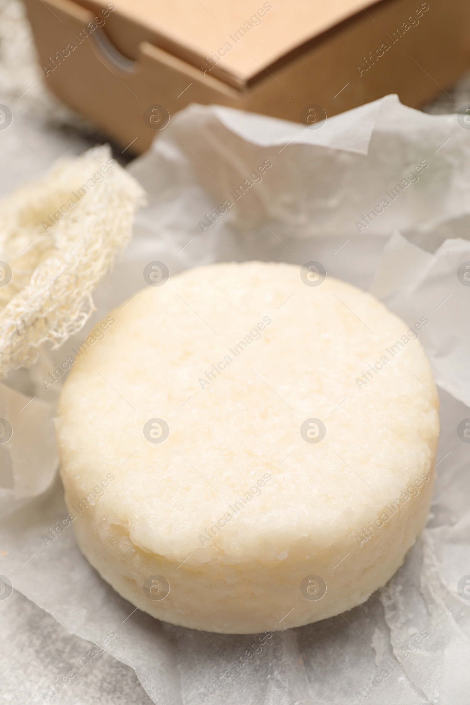 Photo of Solid shampoo bar on light grey table, closeup