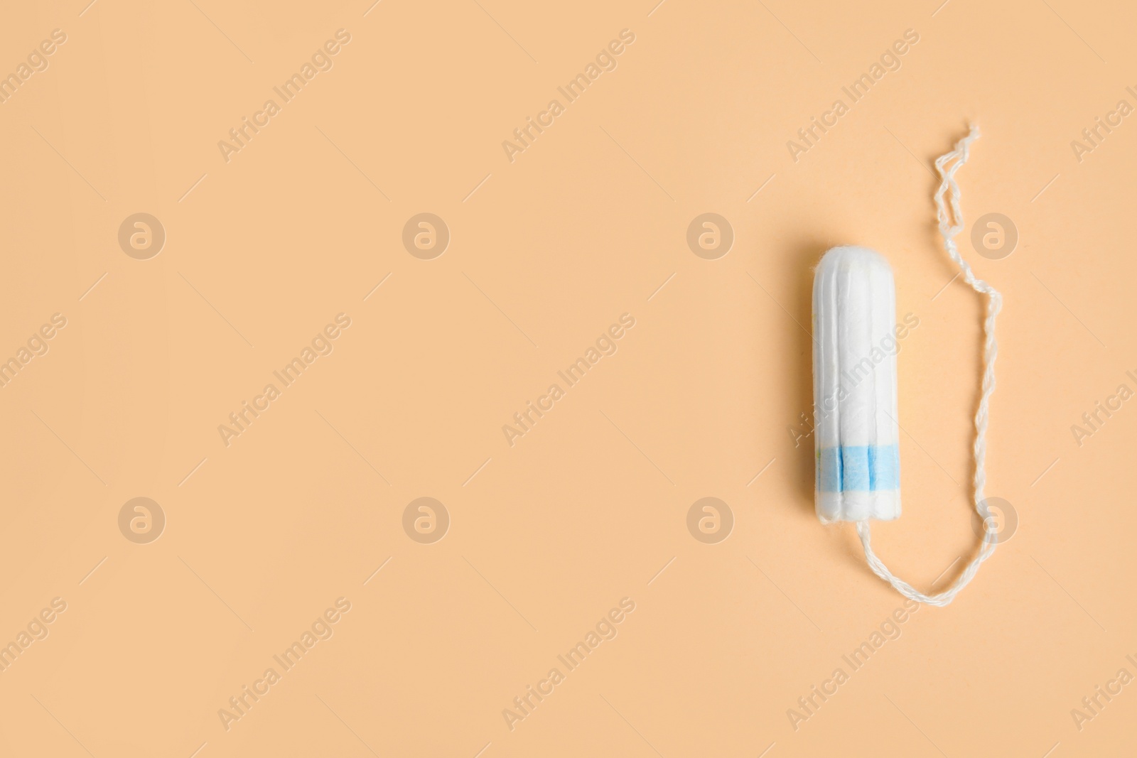 Photo of Tampon on beige background, top view. Space for text