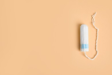 Photo of Tampon on beige background, top view. Space for text
