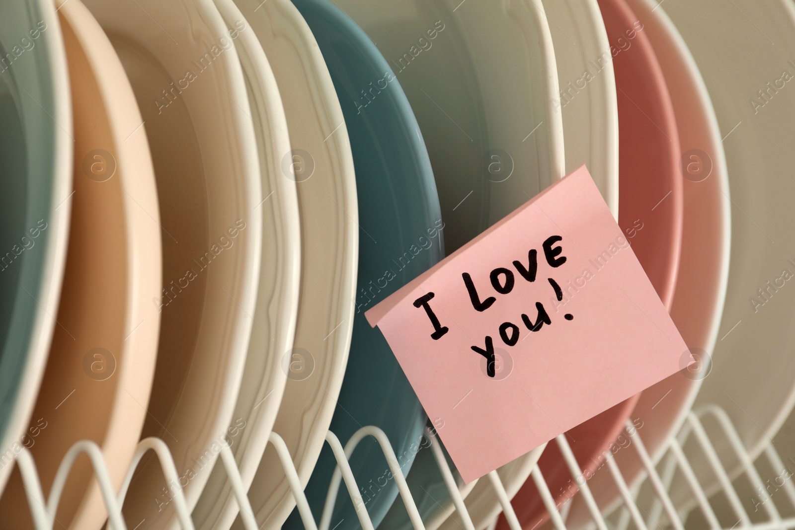 Photo of Sticky paper with words I Love You on clean plates