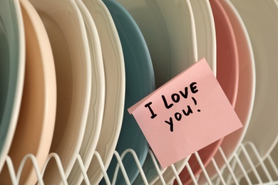 Photo of Sticky paper with words I Love You on clean plates