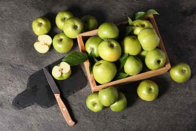 Ripe green apples, cutting board and knife on grey table, flat lay