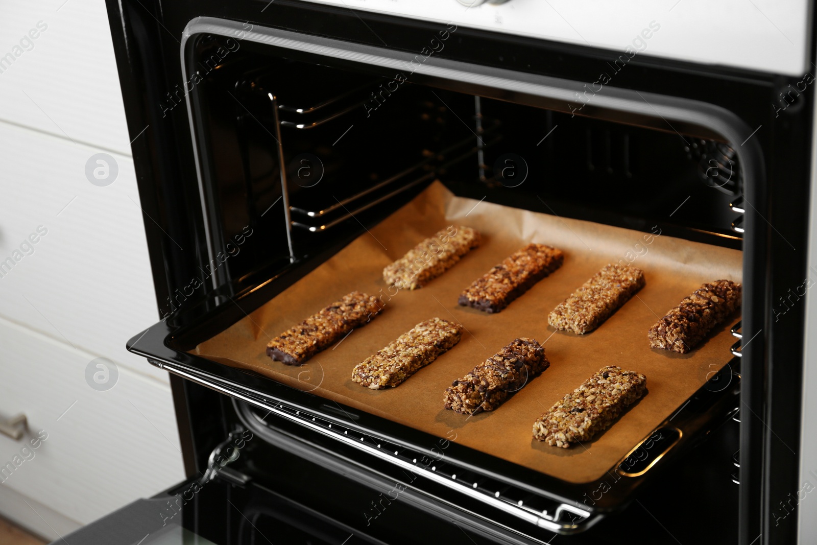 Photo of Delicious healthy granola bars on baking sheet in oven