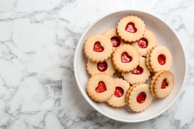 Photo of Traditional Christmas Linzer cookies with sweet jam on plate, top view