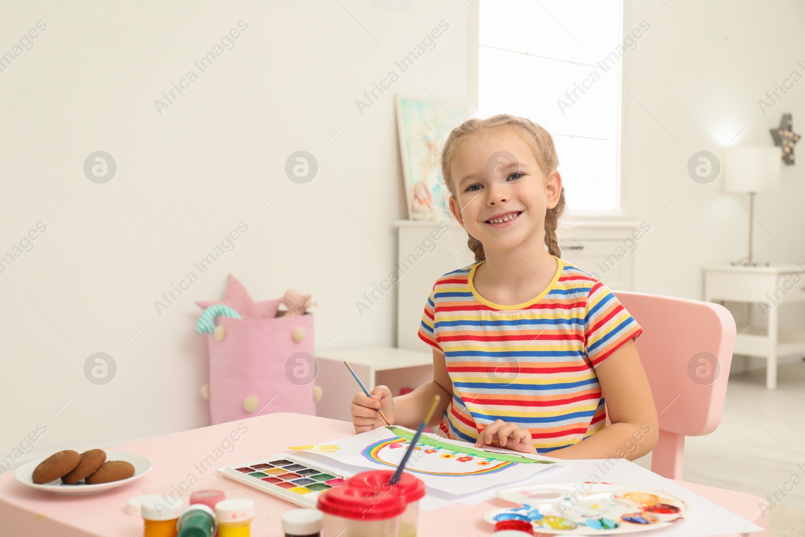 Photo of Cute little child painting at table in room