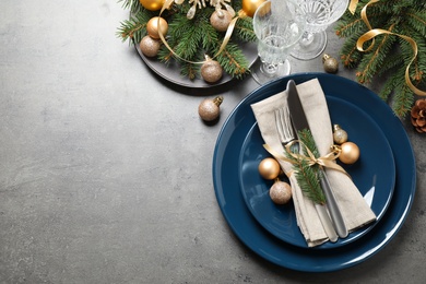 Festive table setting with beautiful dishware and Christmas decor on grey background, flat lay. Space for text