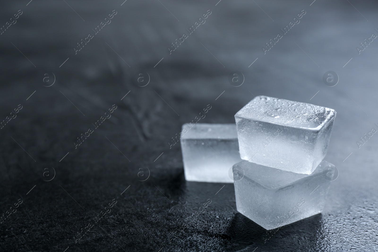 Photo of Ice cubes on grey surface, closeup. Space for text